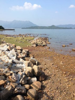 berrak mavi okyanusları ve uzak dağları olan kayalık kıyı şeridi