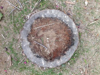 Toprak ve sopalarla dolu dairesel taş halka.