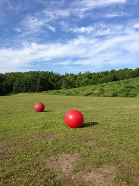 Yeşil çimenlikte iki büyük kırmızı küre