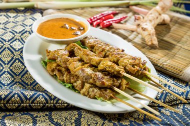 Zengin fıstık sosu ve taze garnitürle servis edilen ızgara satay şiş..