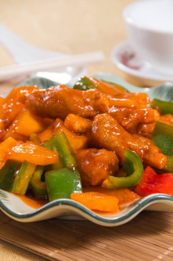 Çan biberi ve ananas parçalarıyla kızartılmış bir tabak tatlı ve ekşi domuz eti..