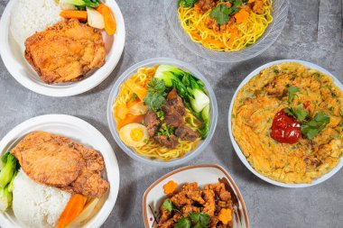 Yeşillik, sığır eti ve yanında pirzola ve yumuşak omlet tabakları olan birkaç erişte kasesinin üst görüntüsü. Parlak renkler ve düzgün kaseler gündelik, tatmin edici bir kantin tarzı.