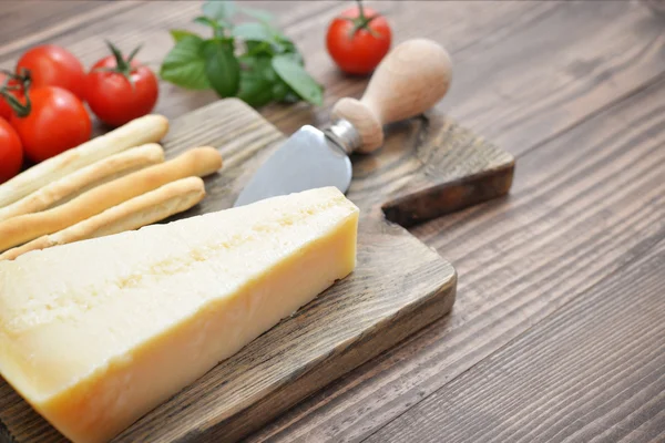 Parmesan cheese on cutting board — Stock Photo, Image