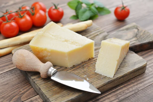 Parmesan cheese on cutting board — Stock Photo, Image