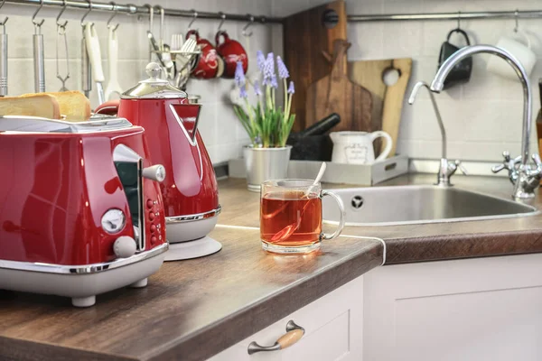 厨房内密闭的带面包和茶帽的复古泥浆中的红色电水壶和烤面包机 — 图库照片