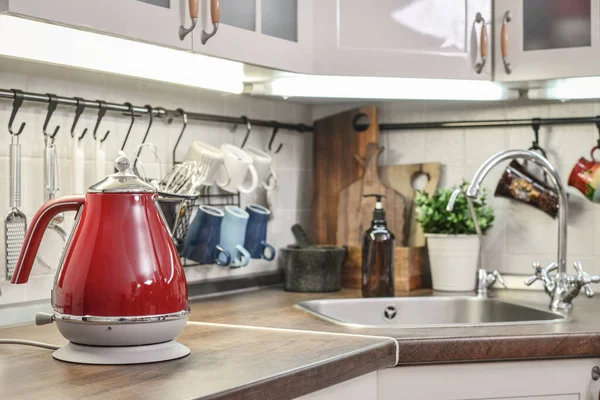 Red electric kettle in retro slile  in kitchen interior closeup