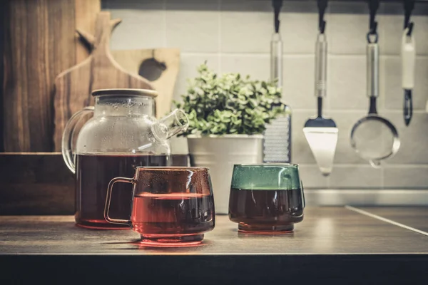 杯子茶壶 茶壶里满是红茶 厨房工作台上有两杯茶 — 图库照片