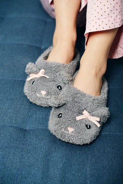 Vrouwelijke benen in leuke slippers — Stockfoto