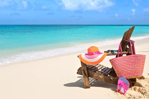 Sedia con borsa, cappello, infradito e occhiali da sole sulla spiaggia soleggiata — Foto Stock