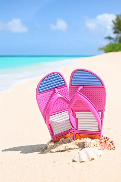 Rosa Flipflops an einem sonnigen Sandstrand — Stockfoto