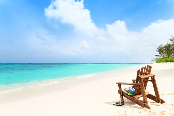 Sedia da spiaggia solitaria con cappello e pantofole sulla spiaggia tropicale, summ — Foto Stock