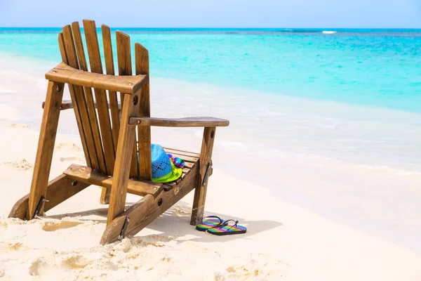 Wooden beach chair with hat and slippers and sunglasses at tropi — Stockfoto