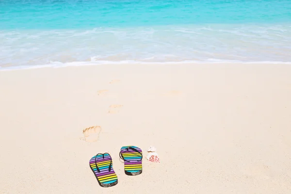 Güneşli bir plaj çok renkli parmak arası terlik — Stok fotoğraf