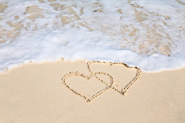 Dos corazones dibujados en la arena de la playa — Foto de Stock