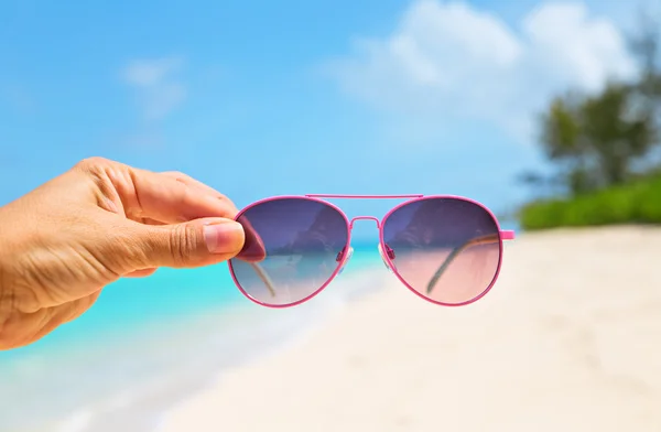 Mão segurando óculos de sol rosa — Fotografia de Stock