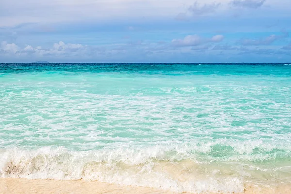 Kristal berrak okyanus suyu ve mavi gökyüzü arka planlı kıyı