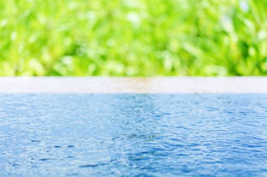 Mavi yüzme havuzu suyu ve yeşil yemyeşil zemin, seçici odak