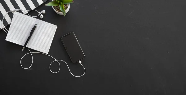 Office black and white workspace with office supplies and copy space on black background, flat lay