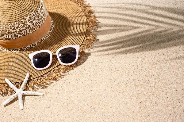Velké hnědé kulaté letní teplo, bílé sluneční brýle a hvězdice na pěkné pláži písek, horní pohled, kopírovací prostor — Stock fotografie
