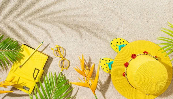 黄色の丸い帽子 メモ帳 オレンジの熱帯の花と砂浜のヤシの葉のサングラス 夏の熱帯の概念 — ストック写真