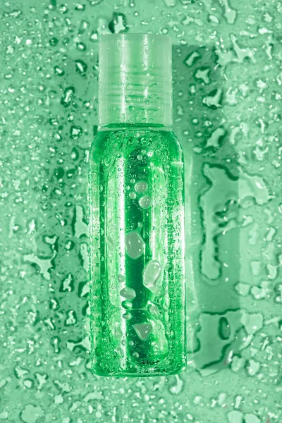 绿色底座上有水滴的透明小瓶子，顶视图 — 图库照片
