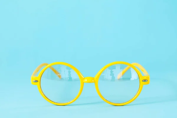 Runde gelbe Gläser auf hellblauem Hintergrund mit Kopierraum. lizenzfreie Stockfotos