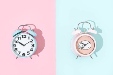 Pembe ve mavi zemin üzerinde eski moda mavi ve pembe çalar saat, kopyalama alanı ile düz yatıyordu