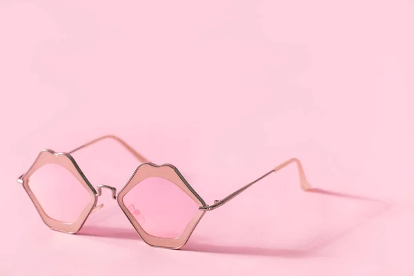Elegantes gafas de sol rosas en forma de labios sobre fondo rosa con sombra y espacio para copiar — Foto de Stock