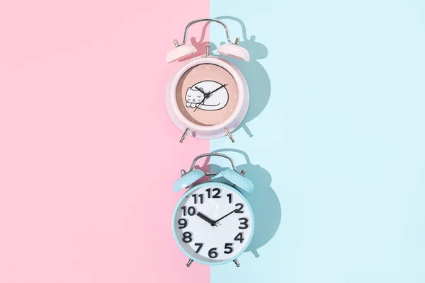 Relógio de alarme de moda antiga em fundo rosa e azul, flat lay com espaço de cópia — Fotografia de Stock
