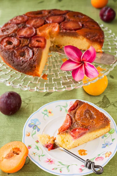 Hausgemachter Zwetschgenkuchen auf dem Kopf, mit Scheibe auf Teller — Stockfoto