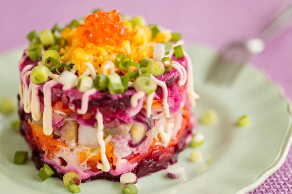 Ensalada tradicional rusa de arenque, en plato verde — Foto de Stock