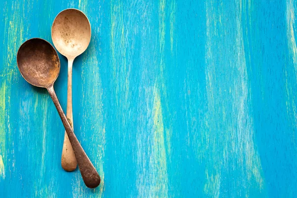 Two Old vintage spoons on blue wooden background, top view — Stock Photo, Image