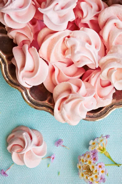 Pink meringue on plate on blue background, macro, selective focu — Stock Photo, Image