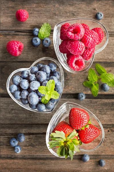 Mix of fresh berries in a glass ramekins in shape of heart, on w — Stock Photo, Image