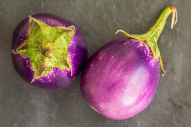 İki bebek boyutu patlıcan, patlıcan taş için arka plan, gri