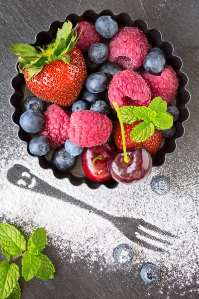 Mix of fresh berries in a small round metal backing mold and sug — Stock Photo, Image
