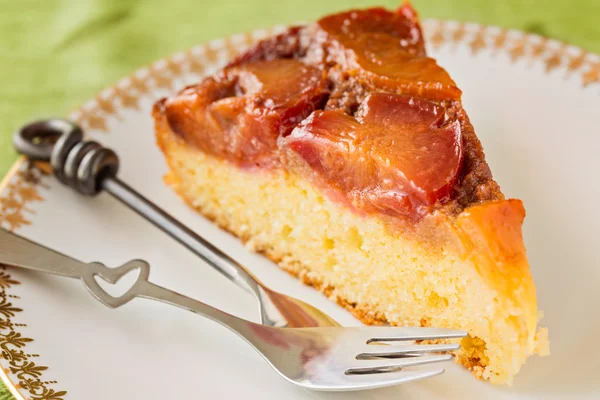 Rebanada de pastel de ciruela casero al revés con dos tenedores en blanco — Foto de Stock