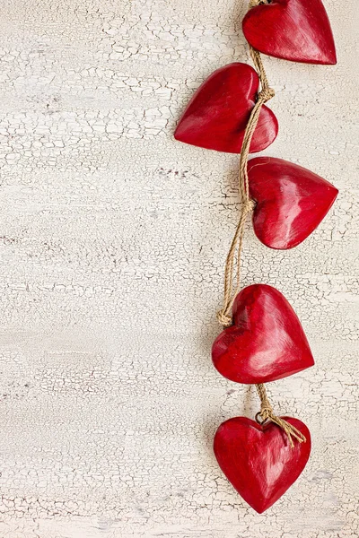 Cuori di legno rosso su vecchio sfondo bianco in legno — Foto Stock