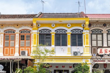 George Town, Penang, Malezya 'da bir miras dükkanının canlı yüzü. Süslü koloni pencereleri ve parlak sarı detaylar geleneksel Boğaz Çin mimarisini gözler önüne seriyor.