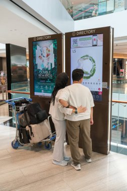 Singapur, Singapur - 3 Ekim 2025 Changi Havaalanı Gri ve beyaz tonlu gösterişli mimari sergiler. Yer araçları mevcut ve bir merdiven bir uçak kapısına doğru gidiyor..