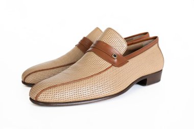 Delinmiş tasarım ve kahverengi deri detaylar içeren şık bej ayakkabılar, hem günlük hem de resmi ayarlar için mükemmel, rahatlık ve stil vurgulanıyor.