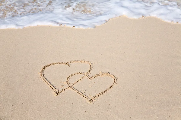 To hjerter tegnet på strandsand – stockfoto