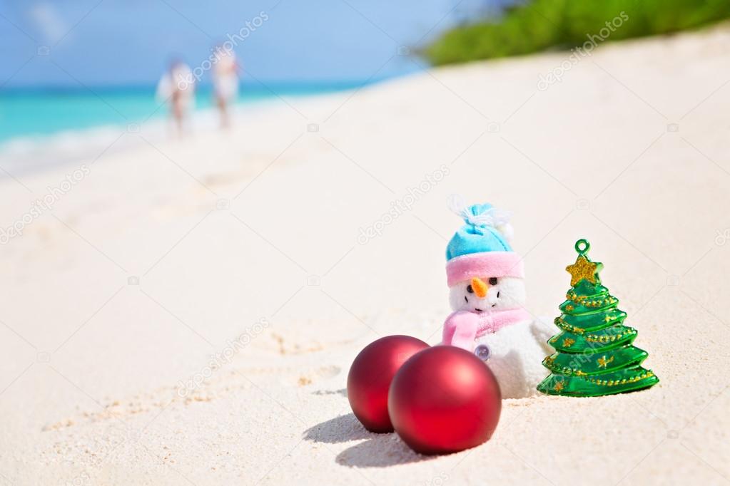 Snowman on the sandy sea beach. Holiday Christmas concept horizo