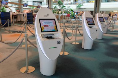 Singapur, Singapur - 3 Ekim 2025 Changi Havaalanı çanta bırakma alanı lüks tasarım, parlak ışıklandırma ve kalabalık bir terminal atmosferinde gezginler için organize sayaç.