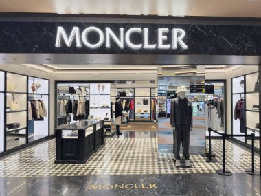 Singapur, Singapur - 31 Temmuz 2025 PRADA mağazası gezginler için lüks moda öğelerini ön plana çıkaran şık bir sırt çantası, el çantası ve aksesuar sergisi sergiliyor.