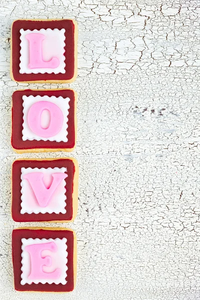Homemade cookies creating word LOVE on white old wooden backgrou — ストック写真