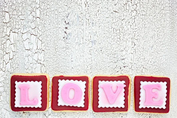 Homemade cookies creating word LOVE on white old wooden backgrou — ストック写真