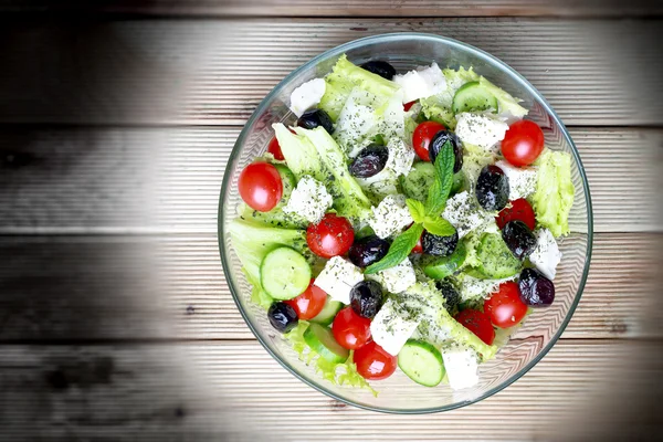 Греческий салат на деревянном фоне — стоковое фото