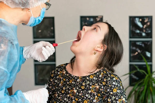 Doktor kızın ağzından, DNA testinden ve PCR testinden örnek alır.