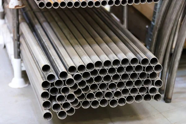 Fabrikadaki raflarda paslanmaz çelik boruların depolanması.